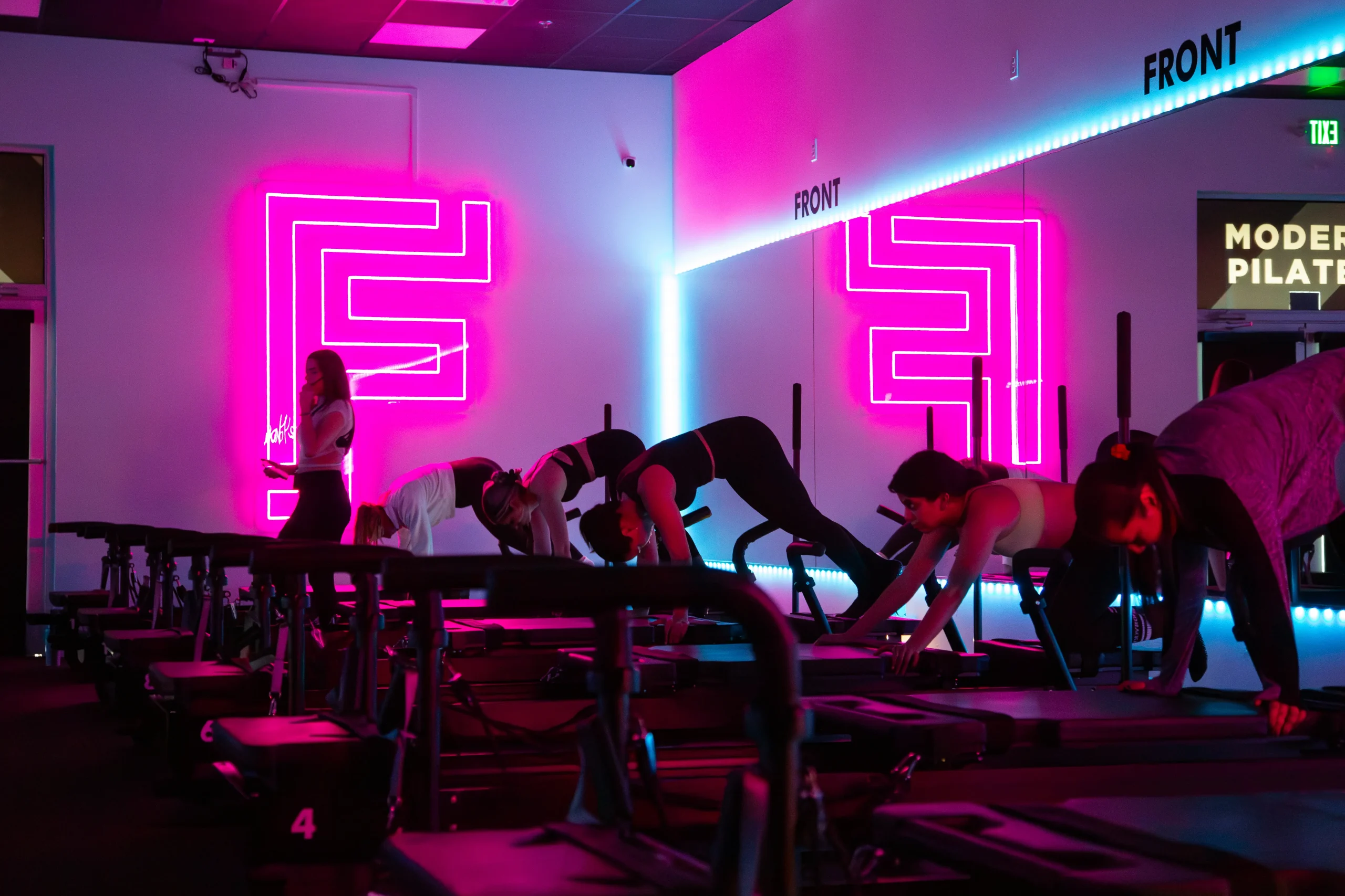 Reformer Class with women performing slow movements to improve strength with time under tension.